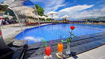 Alberca al aire libre y camastros