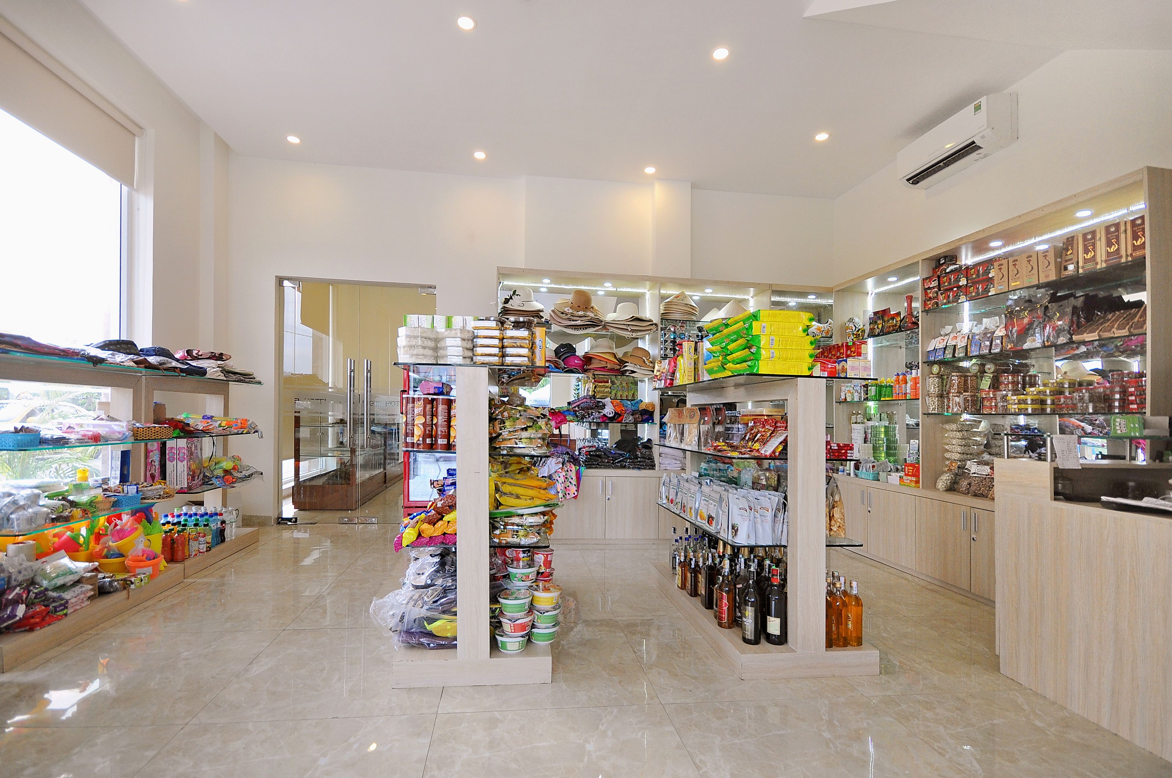 A well-lit store with shelves stocked with various items, including snacks, beverages, and household goods.