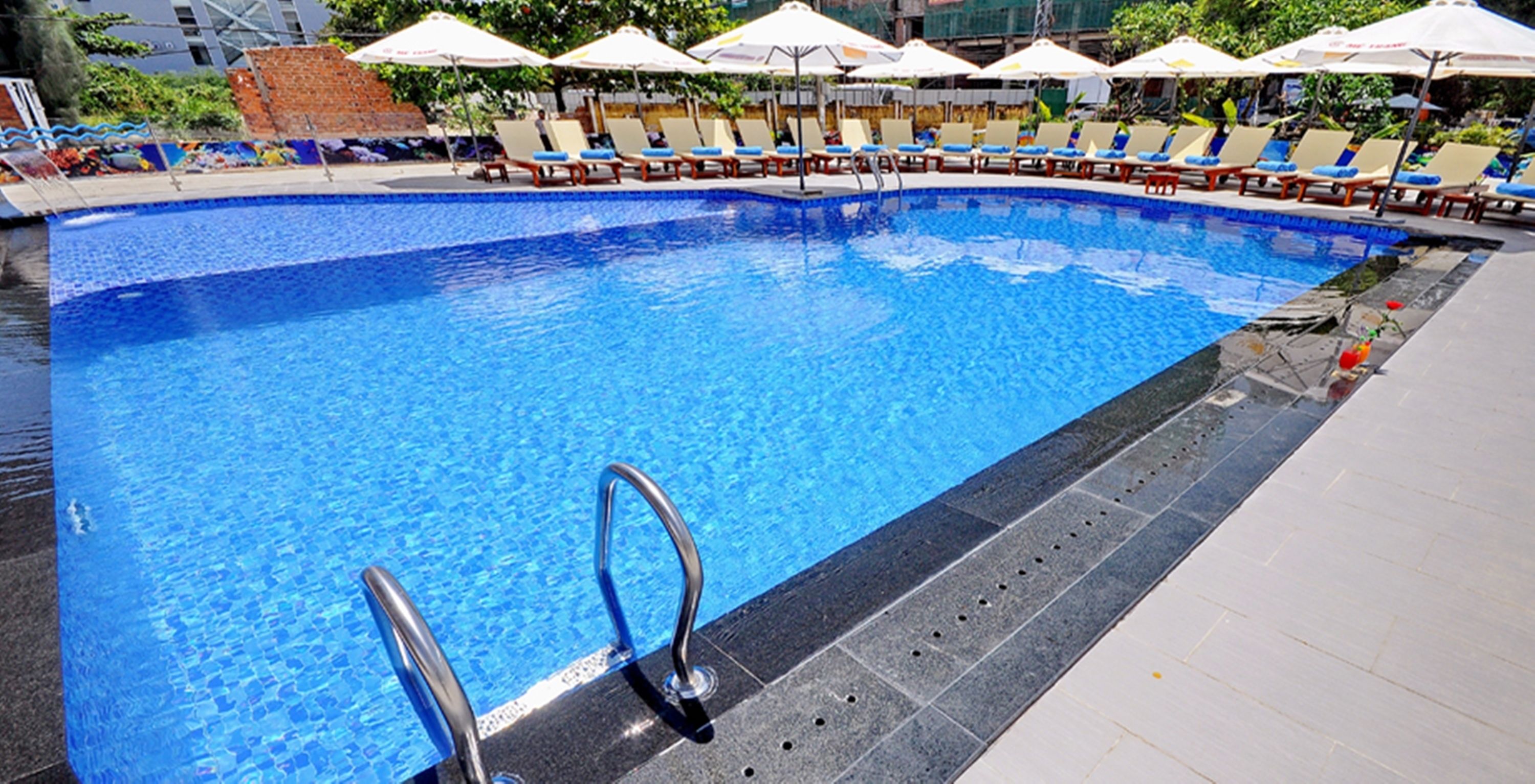 A swimming pool with lounge chairs and umbrellas.