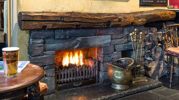 Cozy fireplace with a rustic mantel, perfect for gathering around with a warm meal.
