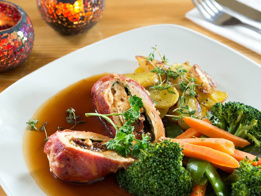 A plate of food with meat, vegetables, and a sauce.