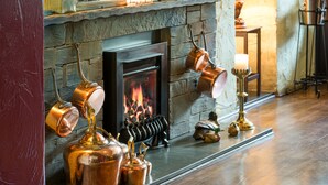 A fireplace with copper pots and kettles hanging above it. - Traveller's Rest Inn (Ambleside)