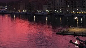 A waterfront cityscape at dusk with buildings reflecting on the water. - Le Stanze sul Mare (Portoferraio)