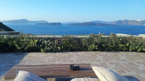 Una terraza con vista al mar y montañas distantes.