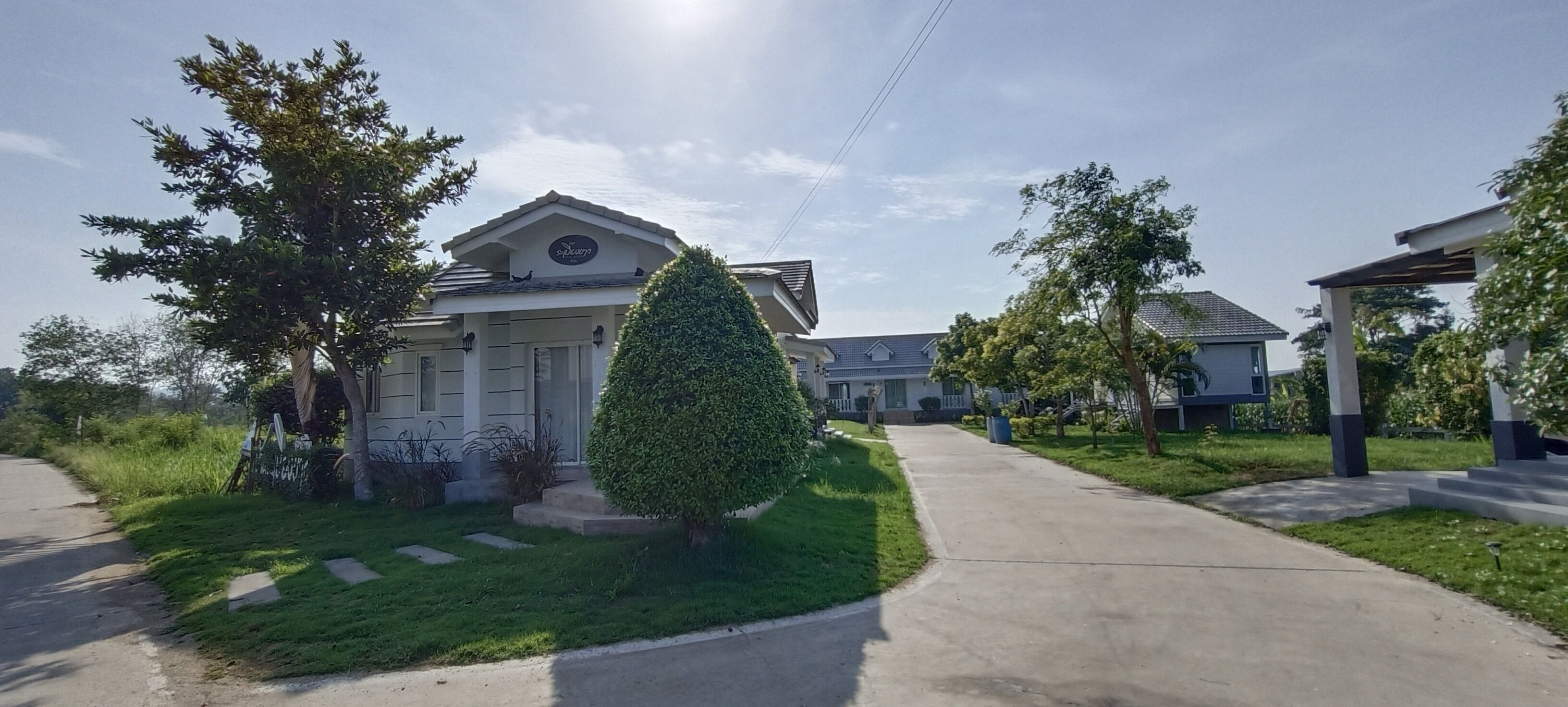 Una zona residencial con casas, un césped cuidado y un cielo despejado.
