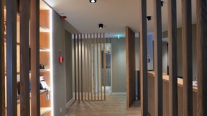 A modern hotel corridor with wooden paneling and a reception desk. - Spot Apartments Trindade (Porto)