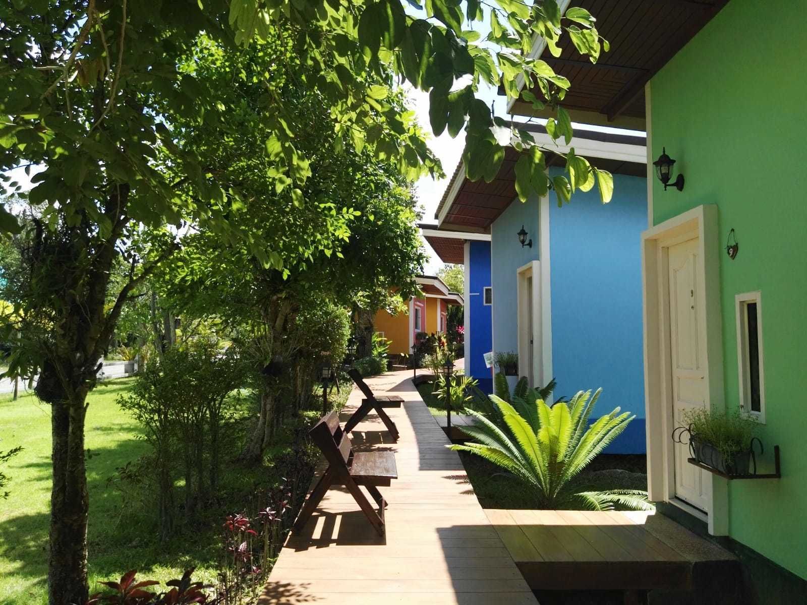 A wooden deck leading to a building with a blue exterior and a white door.
