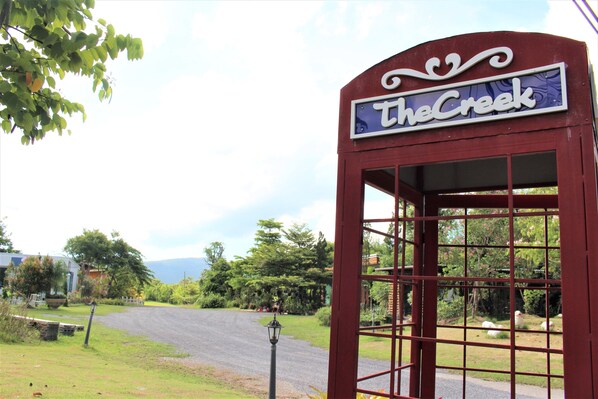 A red telephone booth with a sign that reads "The Creek."