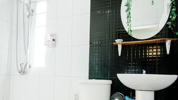 Un baño con inodoro, lavabo y ducha.