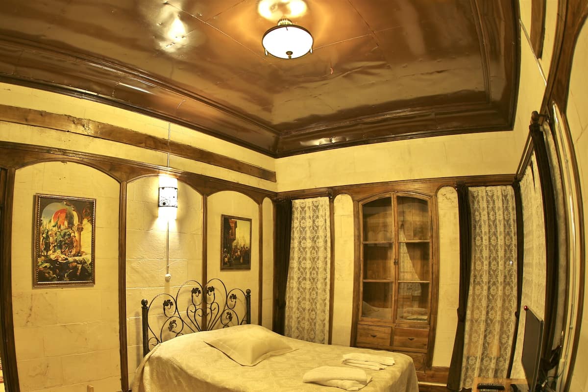 Ein traditionell eingerichtetes Zimmer mit Bett, Holzmöbeln und einem Spiegel.