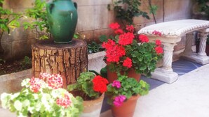 A garden with potted plants and a stone bench. - Ali Bey Konagi (Gaziantep)