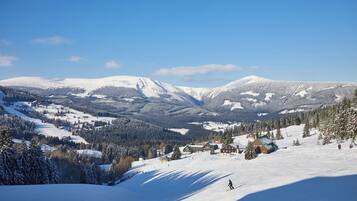 Un paysage montagneux enneigé avec une station de ski, comprenant des bâtiments et des pistes de ski.