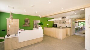 Une cuisine moderne avec des plans de travail en bois, un îlot central et un mur d’accent vert.