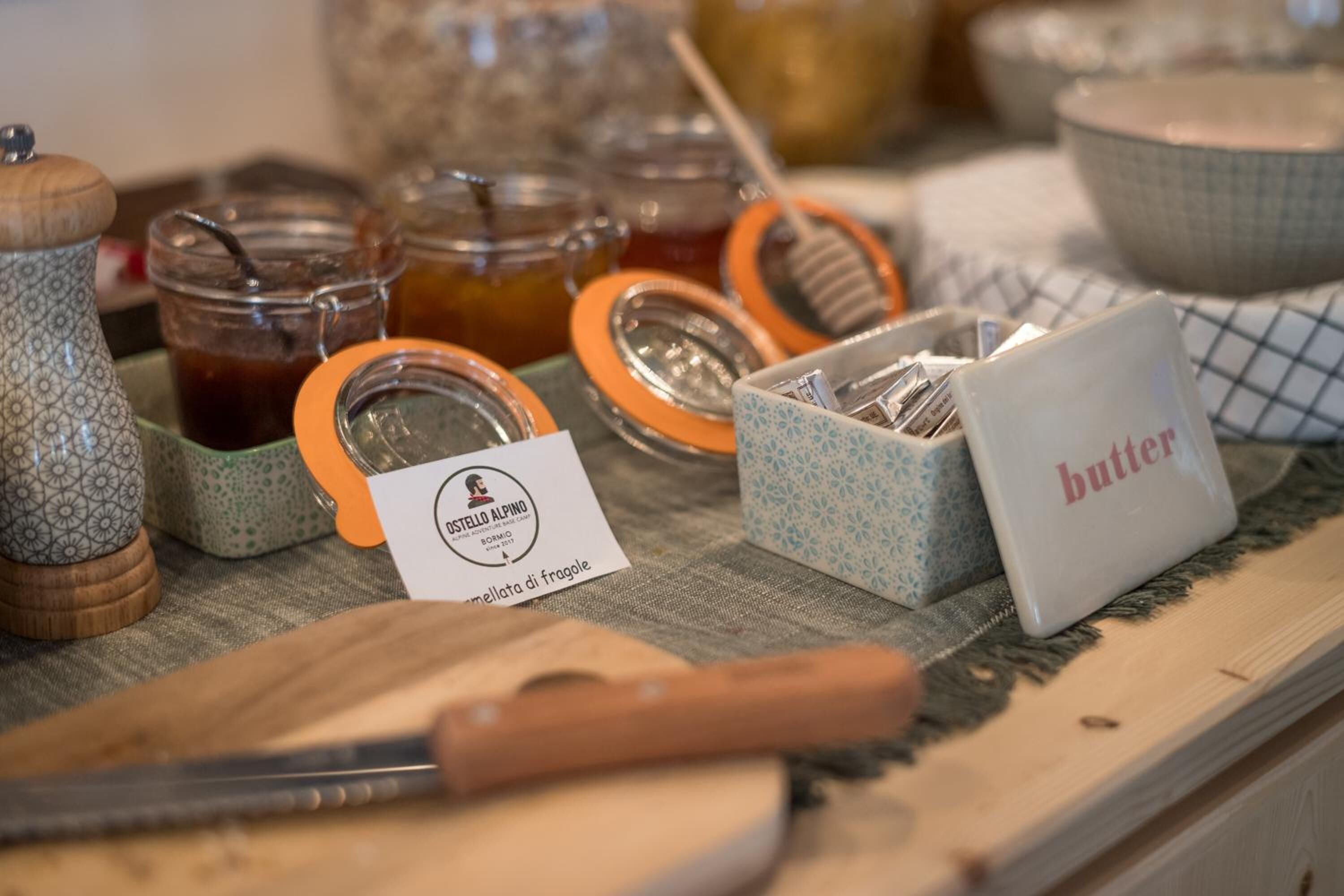 Una encimera de cocina con frascos de miel, un cartel de mantequilla y una tarjeta con un logotipo.