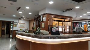 A reception area with a marble counter, framed certificates, and a sign that reads "RECEPTION". - Hotel Residence Memmina (Frosinone)