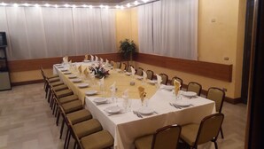 A conference room with a long table set for a meeting, surrounded by chairs. - Hotel Residence Memmina (Frosinone)