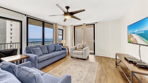 A modern living room with a sofa, armchair, and a flat-screen TV. - Seaside Beach & Racquet 5614 (Orange Beach)