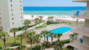 A hotel with a pool, beach view, and multiple balconies. - Seaside Beach & Racquet 5614 (Orange Beach)