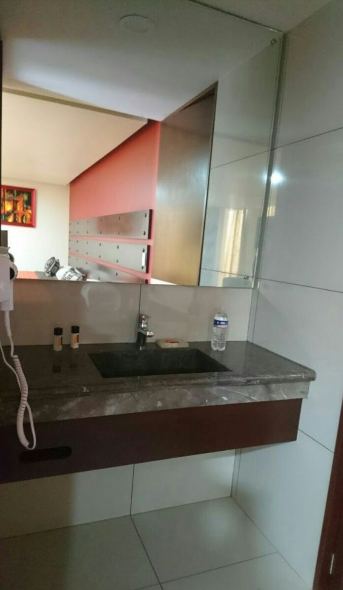 Ein Badezimmer mit Waschbecken, Spiegel und gefliesten Wänden.