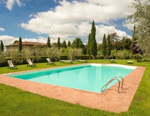 Una piscina al aire libre de temporada, sombrillas