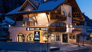 A traditional alpine building with a cafe named "KURZ CAFE" and a restaurant named "BÄCKEREI". - Sportapart Mallaun (See)