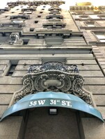 A building facade with a prominent address sign reading "38W 31st ST."
