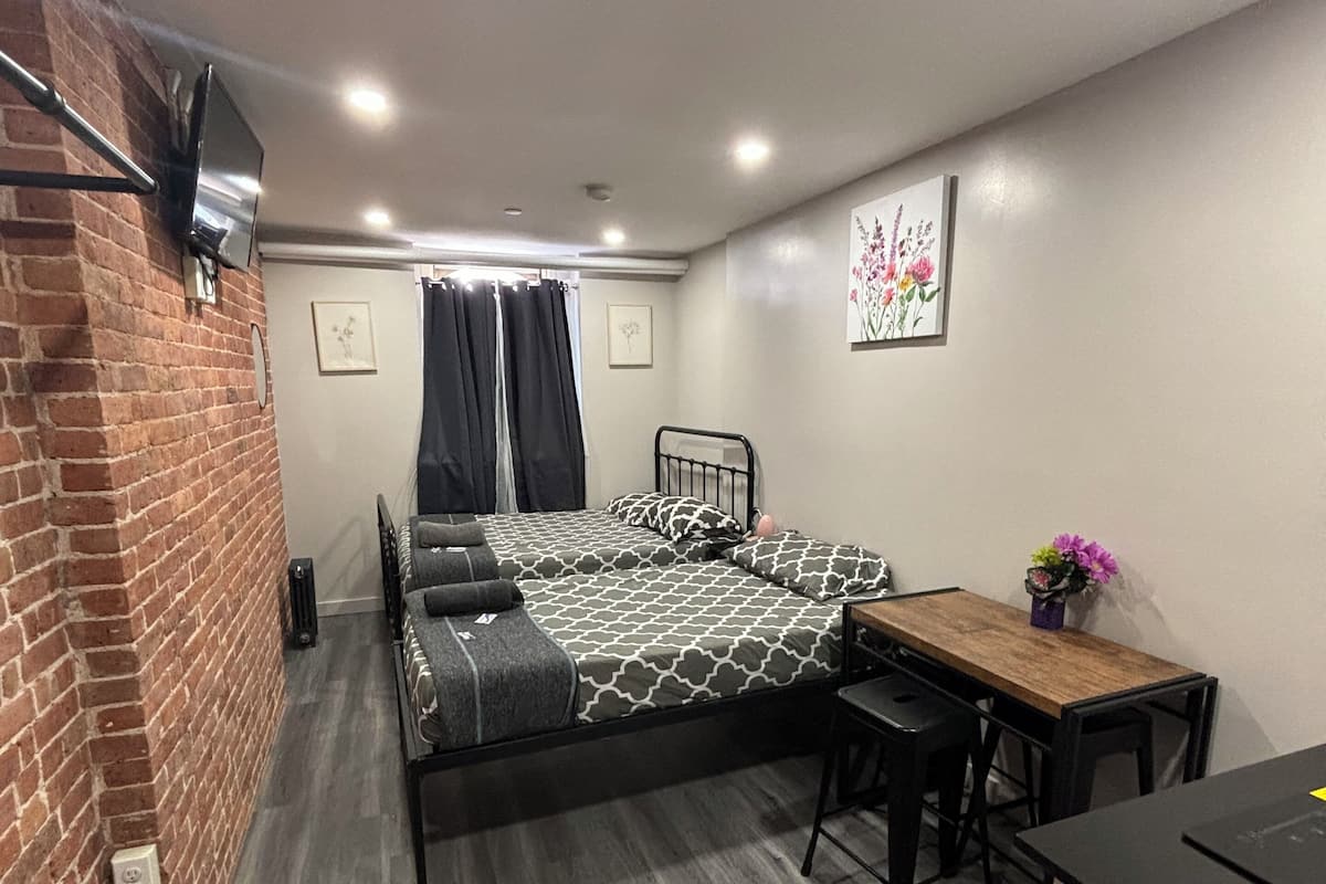 Una habitación compacta con una cama, una mesita y un escritorio.