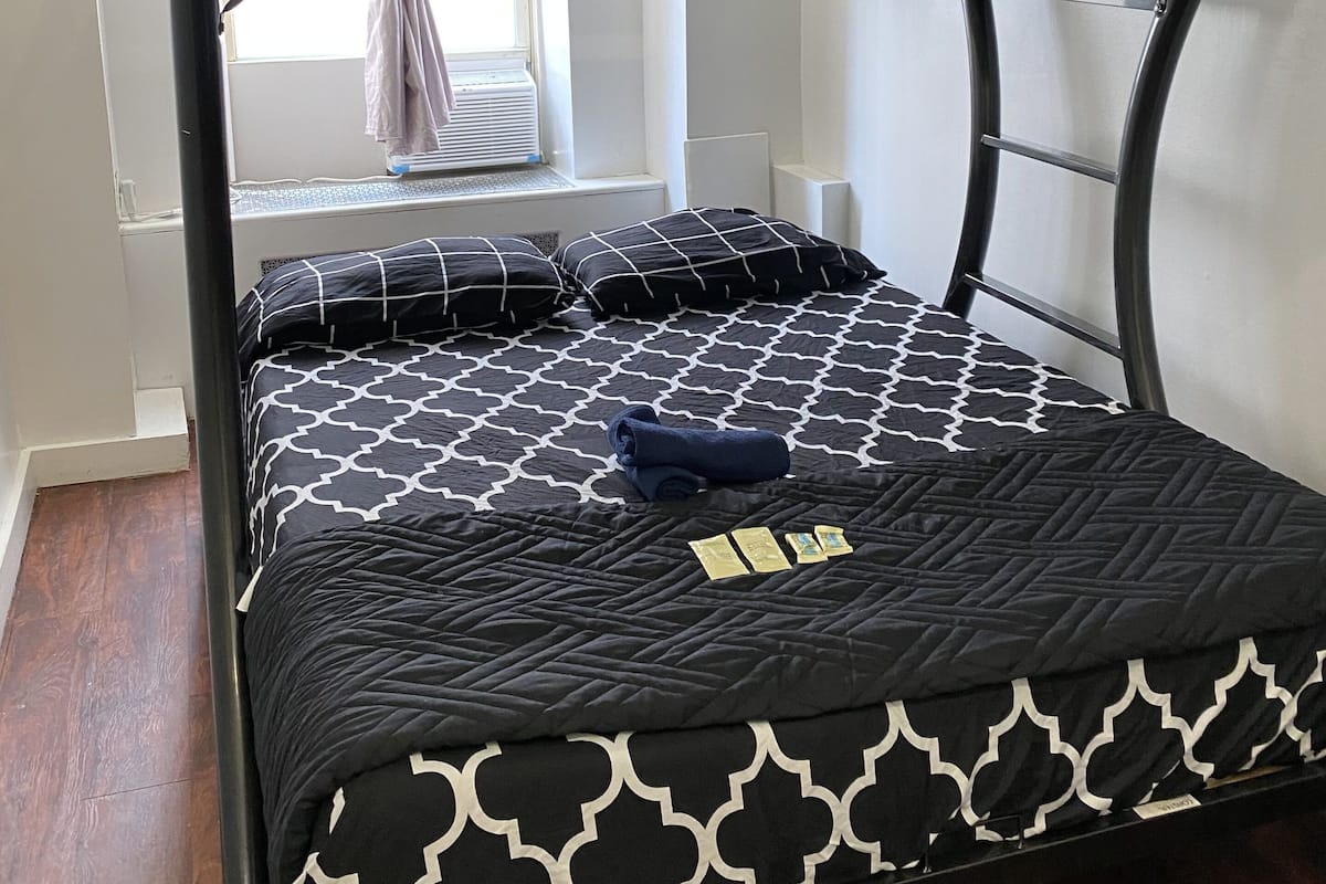 Una cama litera con estructura de metal negro y ropa de cama estampada.