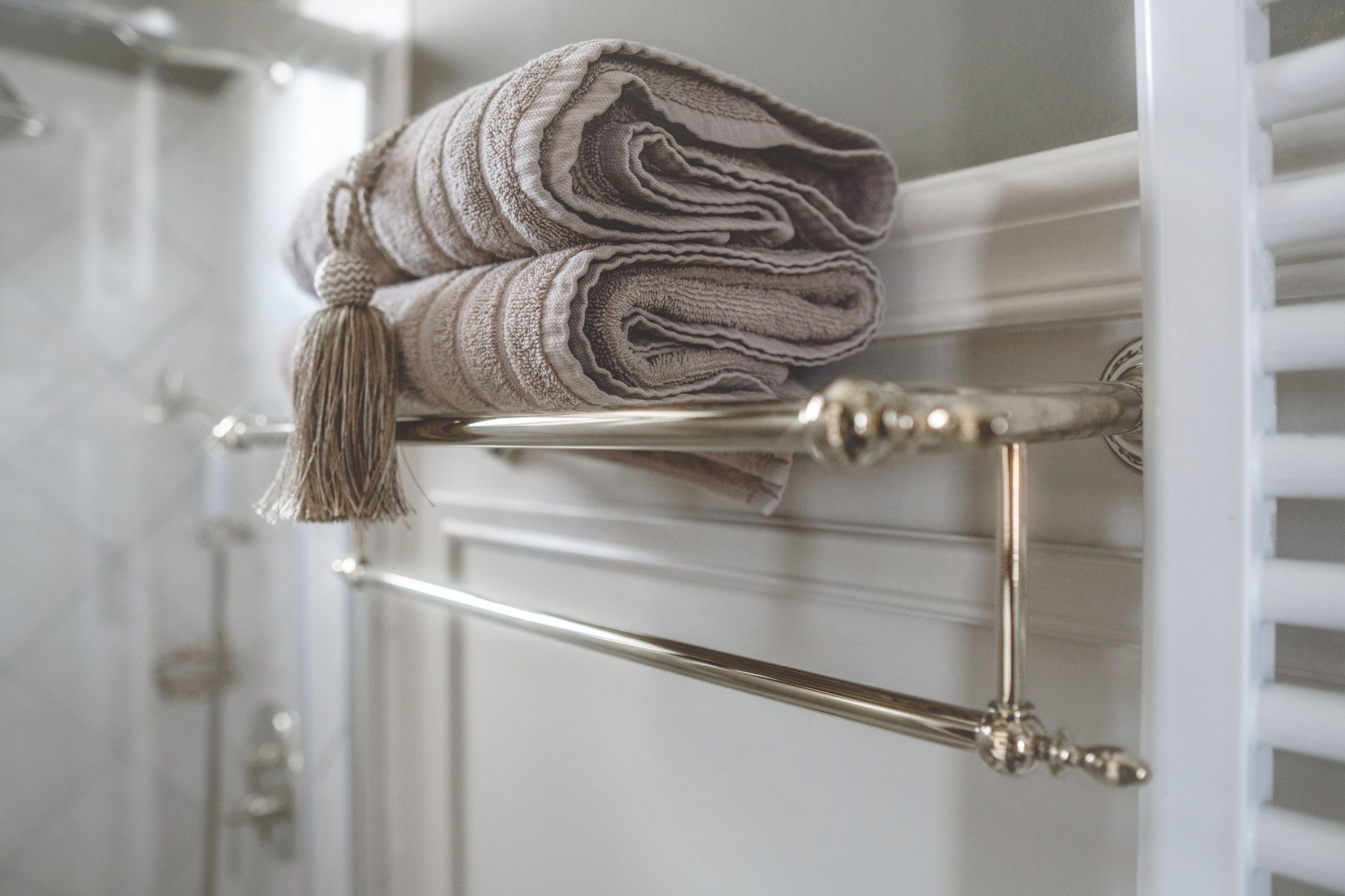 A towel rack with a folded towel and a tassel.