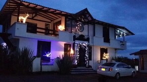 Une maison à deux étages avec une voiture garée devant.