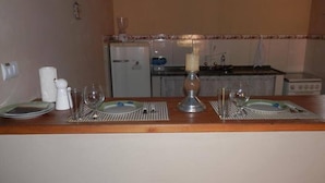 Una cocina con comedor preparado para dos personas.