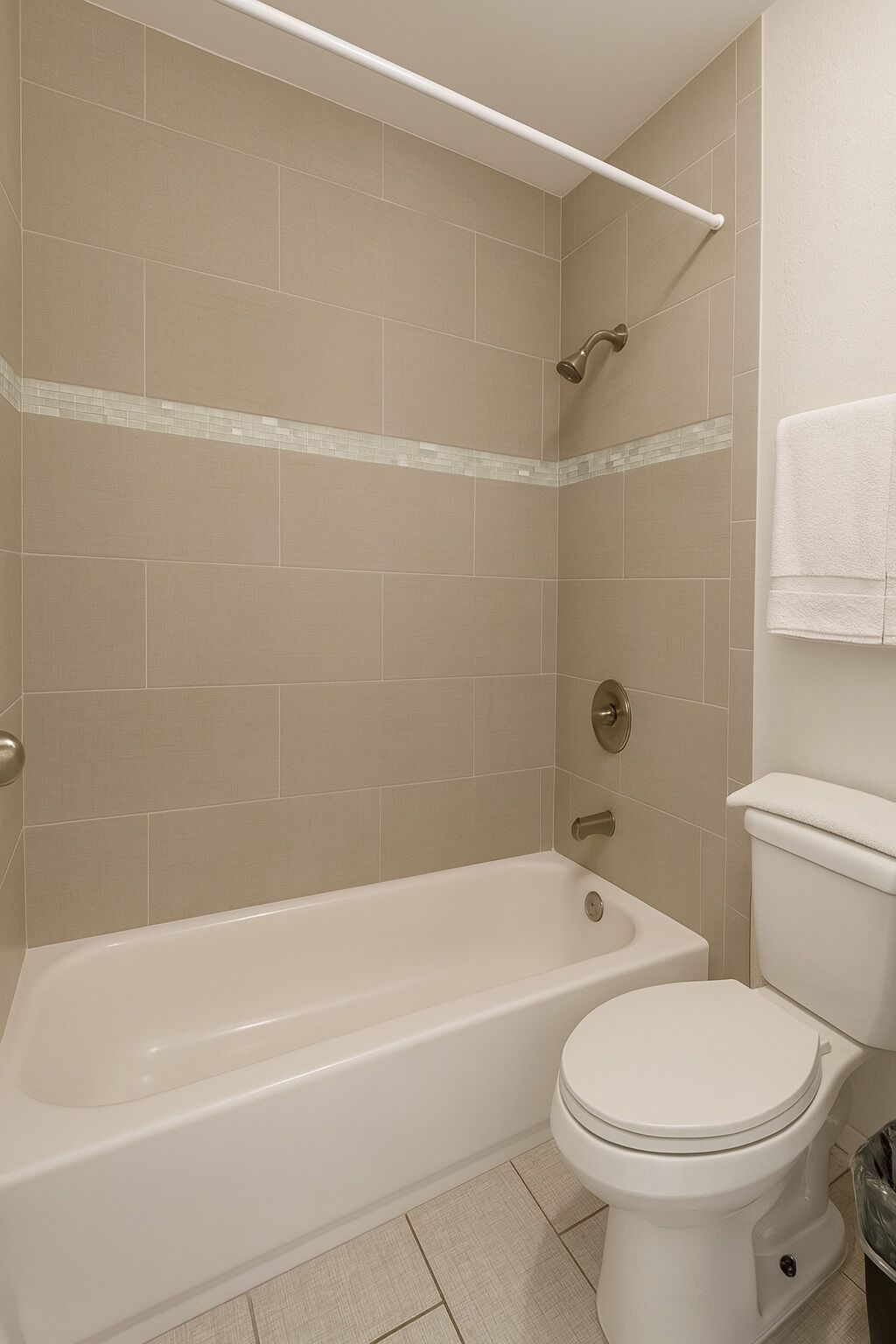 A bathroom with a bathtub, toilet, and a shower area.