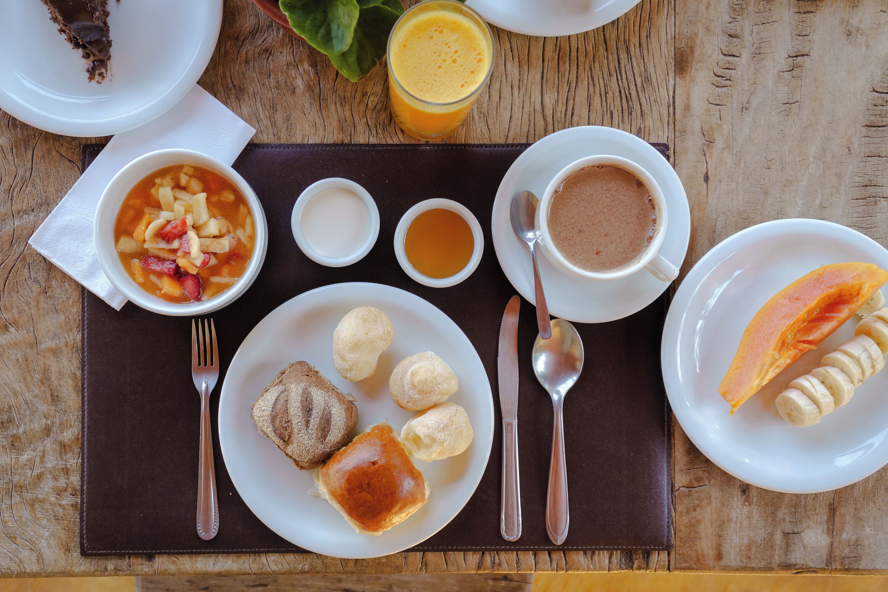 Un desayuno con diferentes alimentos y bebidas sobre una mesa de madera.