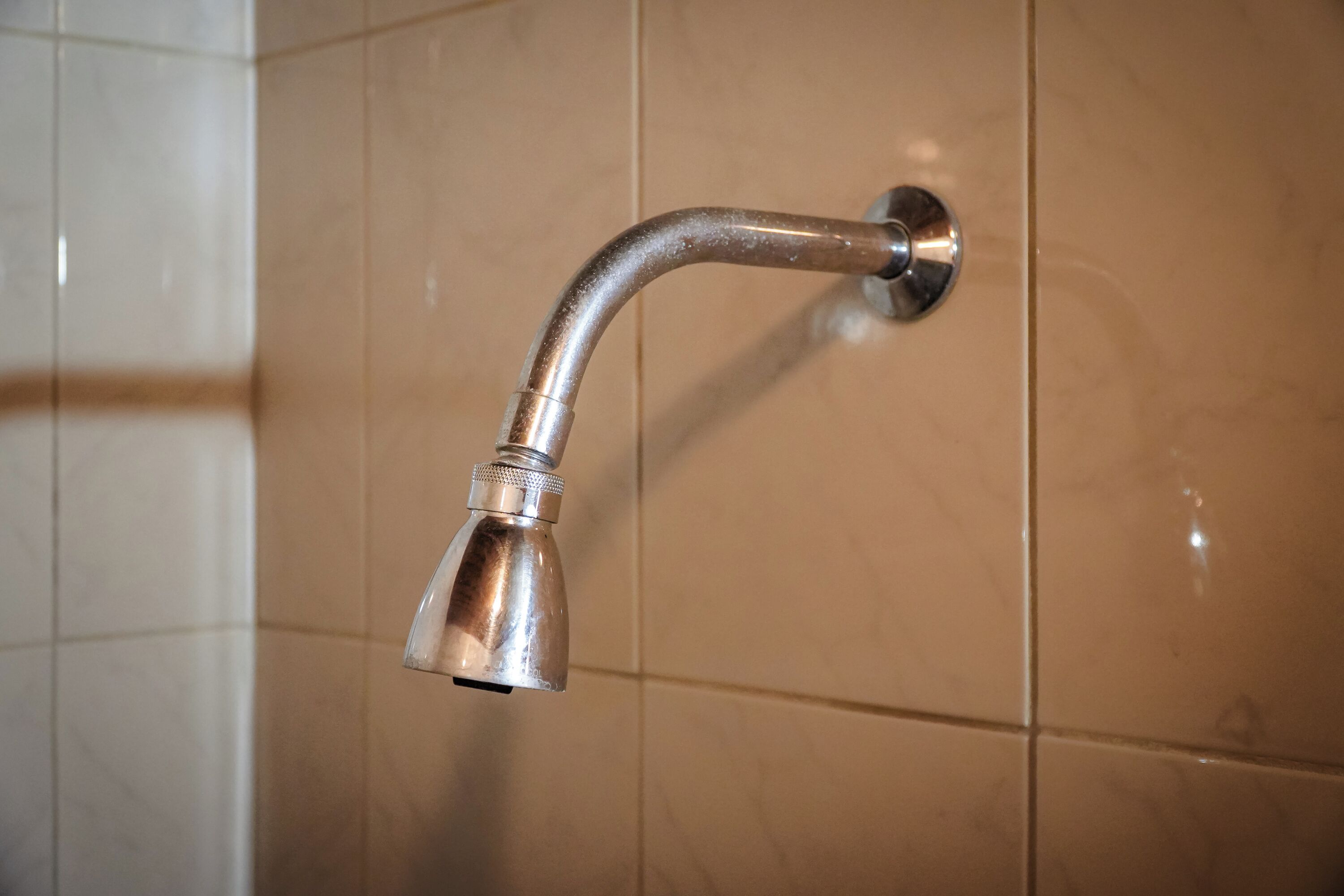 A showerhead mounted on a wall with a curved design.