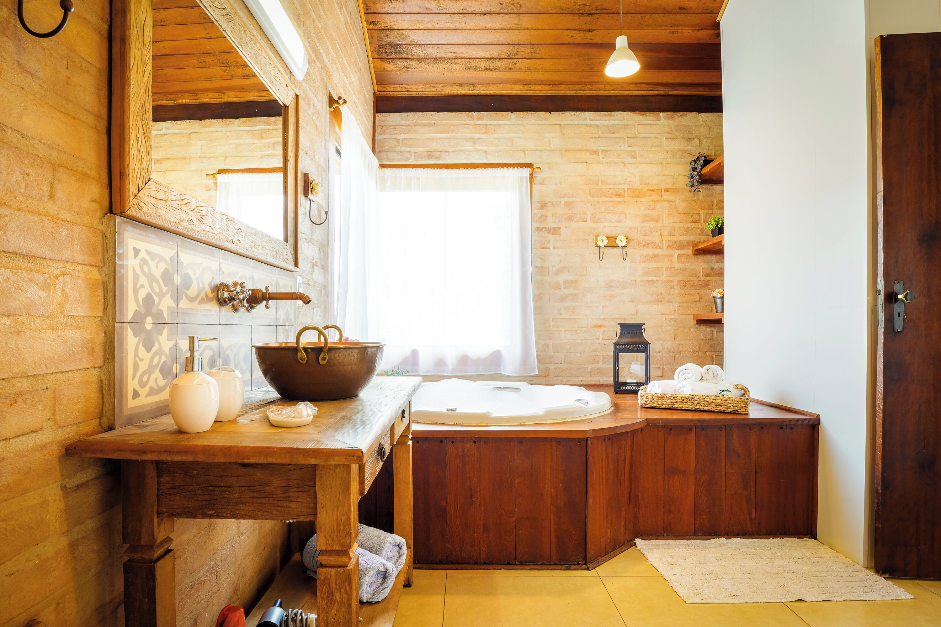 Un baño rústico con una bañera de madera, un espejo grande y un tocador de madera.