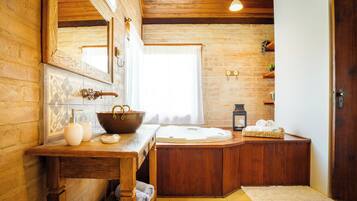 Un baño rústico con una bañera de madera, un espejo grande y un tocador de madera.