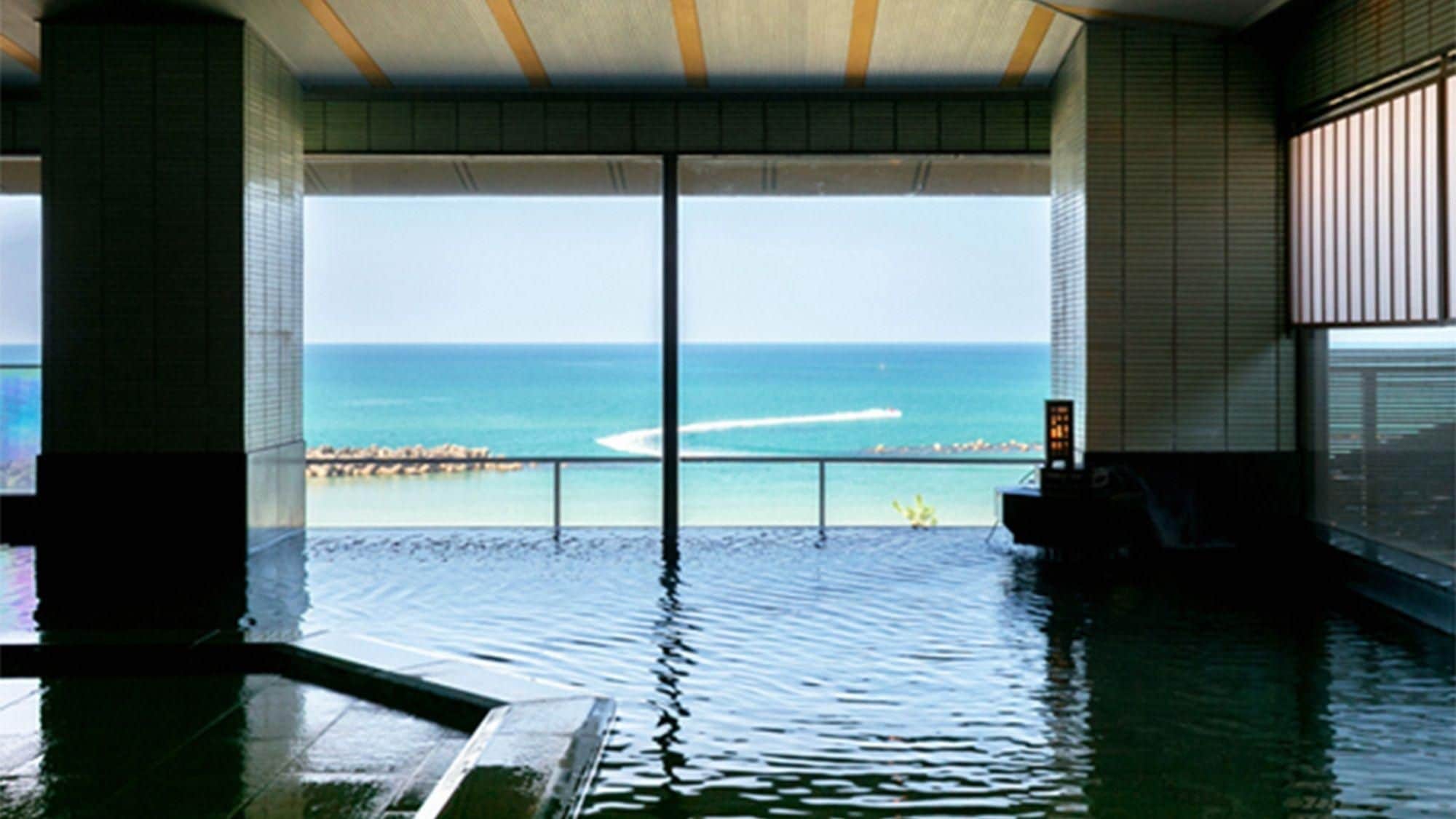 A pool with a view of the ocean and a distant shoreline.