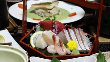 A traditional Japanese meal with sashimi and sushi on a wooden tray.