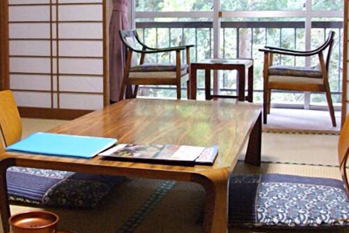Une pièce de style japonais traditionnel, avec des tatamis, une table basse et des portes coulissantes.