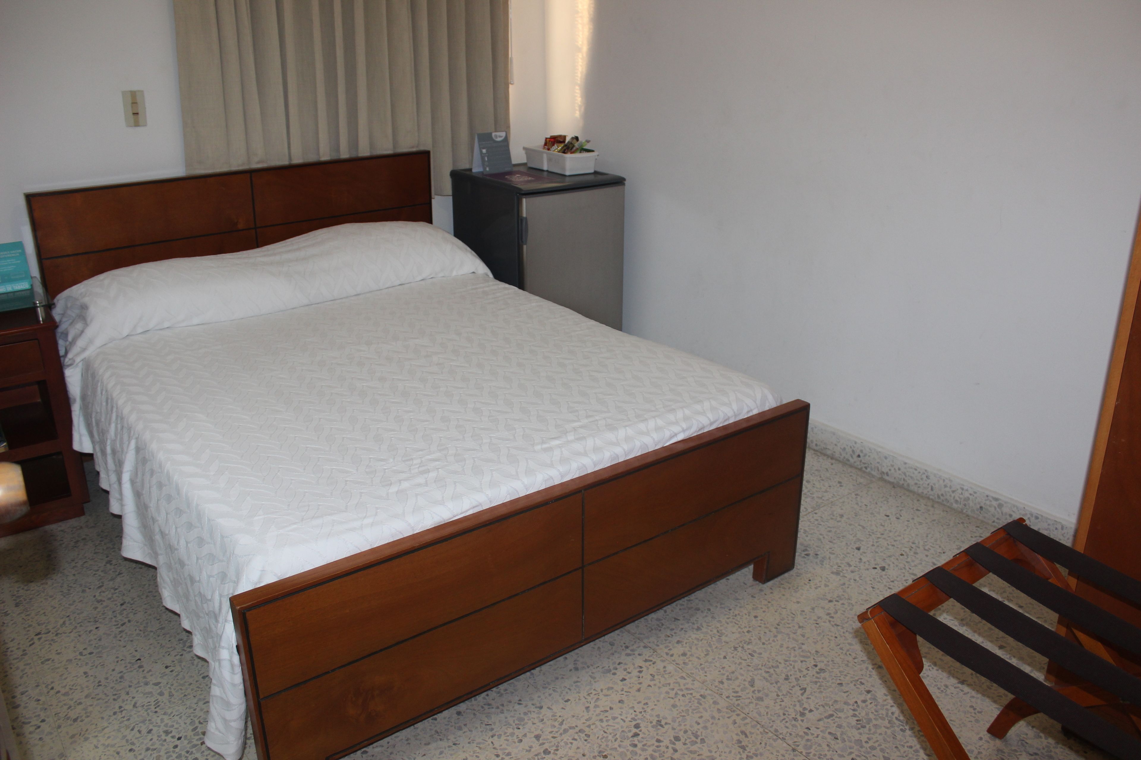 A bedroom with a wooden bed, a small desk, and a chair.