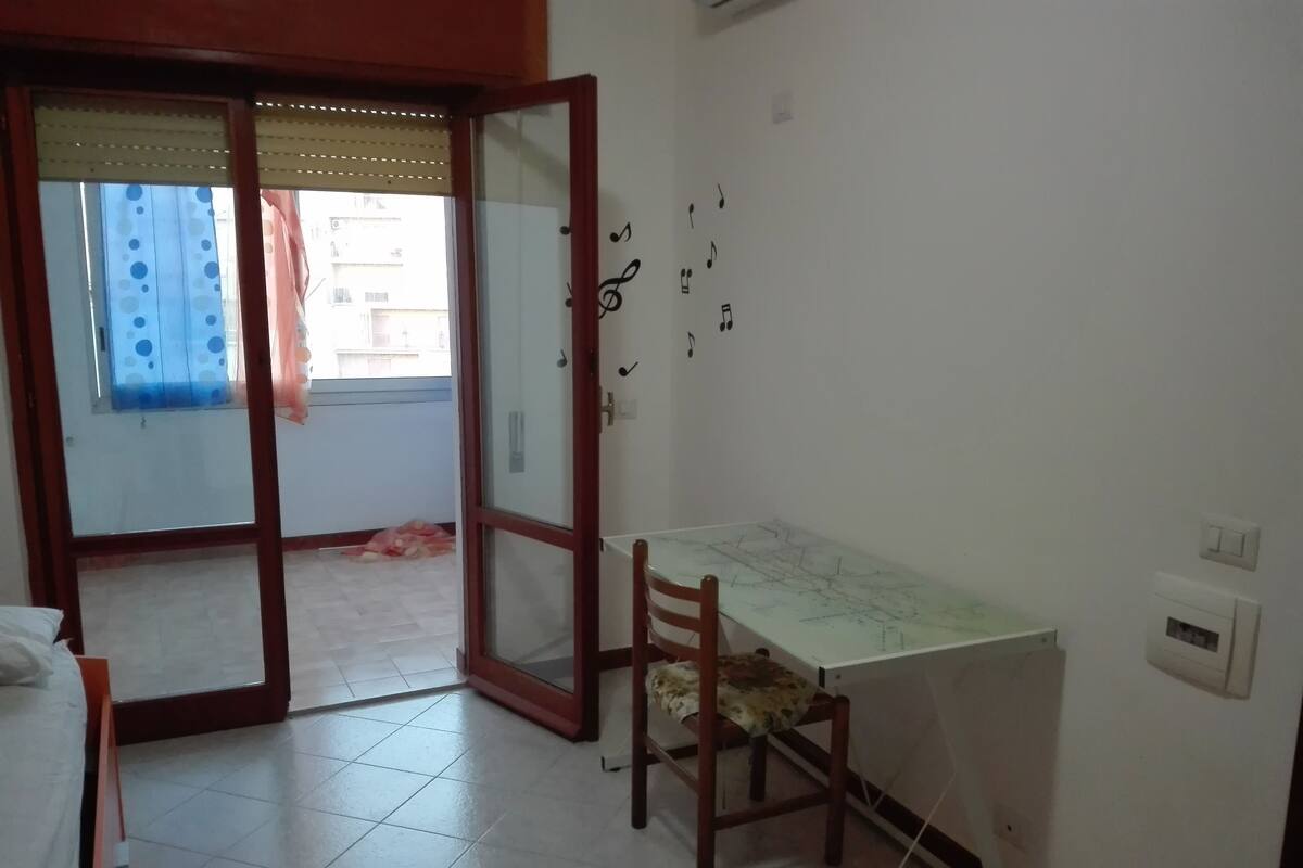 A room with a dining table, a chair, a map on the table, and a door leading outside.