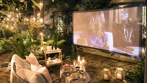 An outdoor cinema setup with a screen, seating, and ambient lighting. - Casa Legado (Bogotá)
