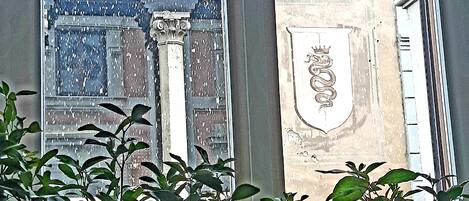 Una ventana con un marco decorativo y un escudo de armas.