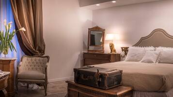 A bedroom with a large bed, a wooden dresser, a chair, and a mirror.
