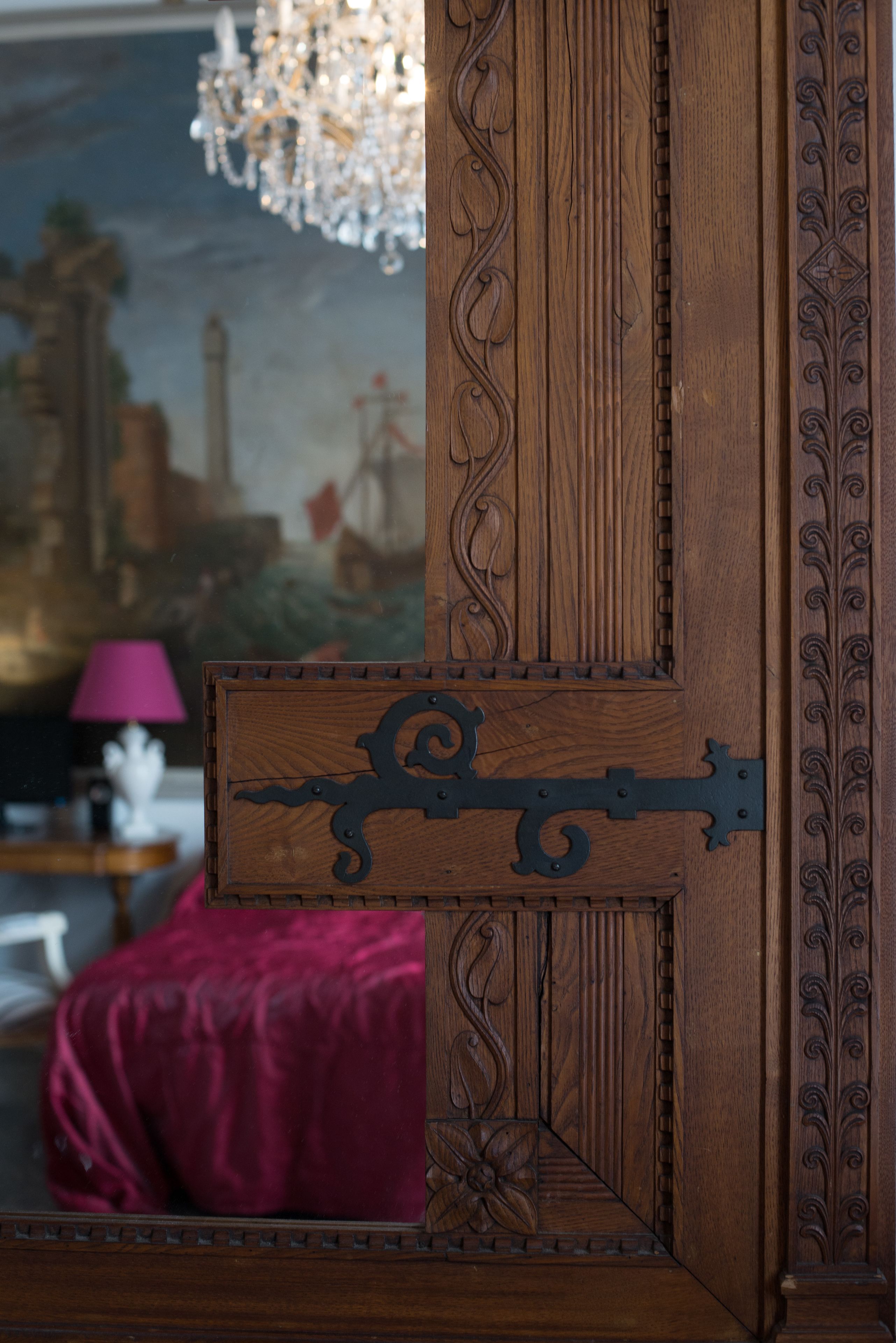 A wooden door with intricate carvings and a metal latch.