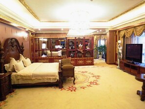 Un dormitorio lujoso con una cama grande, un televisor y un aparador decorativo.