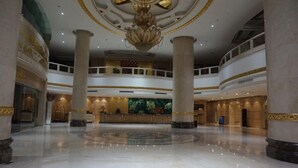 A spacious lobby with a high ceiling, large columns, and a central reception desk. - Rongjiang Hotel (Jieyang)