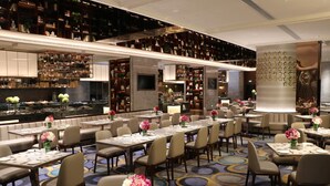A modern hotel lobby with a bar area, seating arrangements, and a decorative wall. - Rongjiang Hotel (Jieyang)