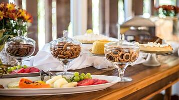 Una mesa de buffet con diversos postres y frutas.