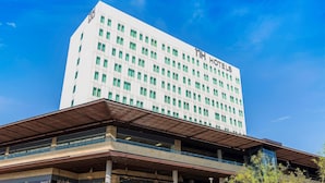 A modern hotel building with a prominent sign reading "The Hotel". - NH Monterrey La Fe (San Nicolas de los Garza)